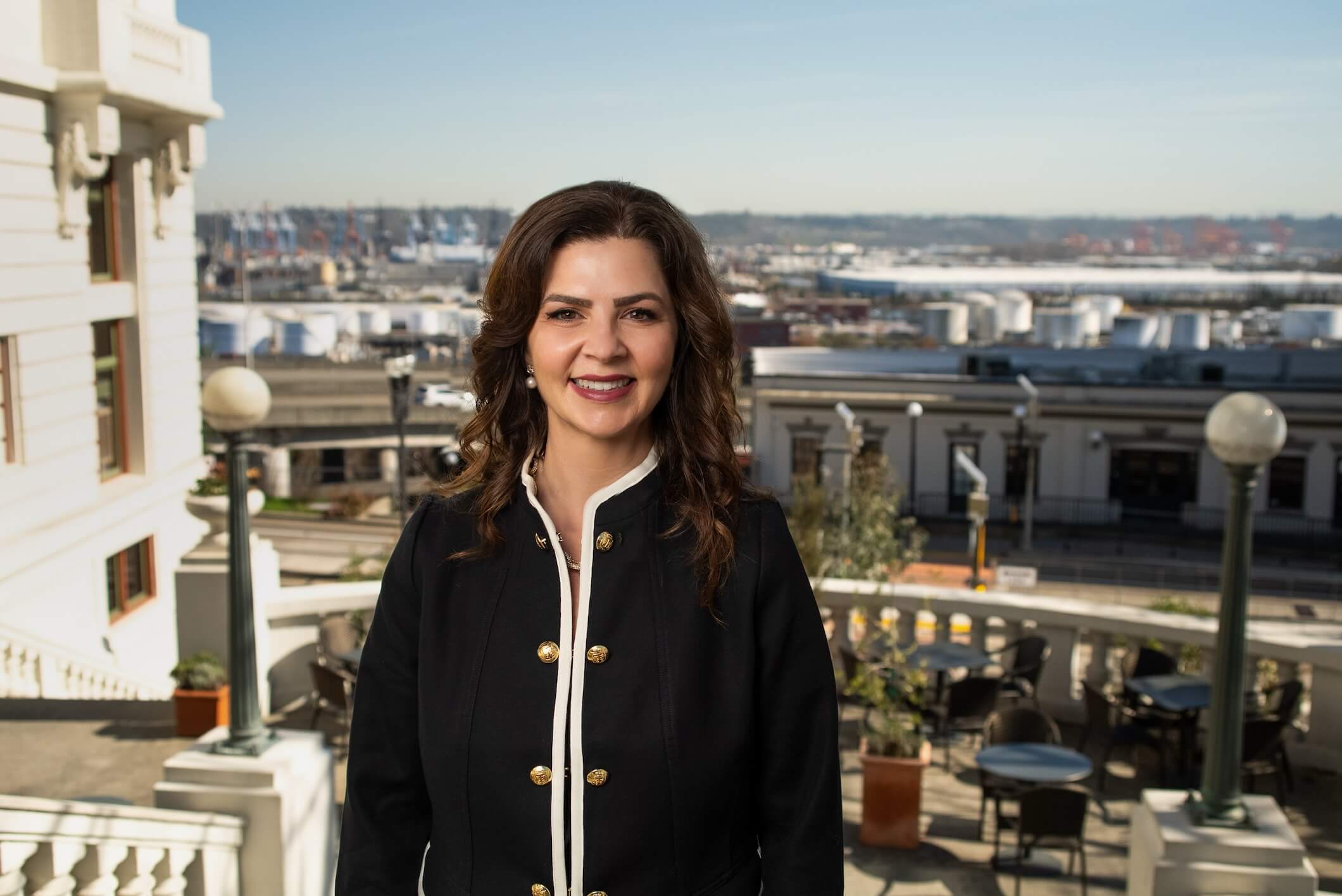 Headshot of Kelly Chambers standing outside on a balcony overlooking the city