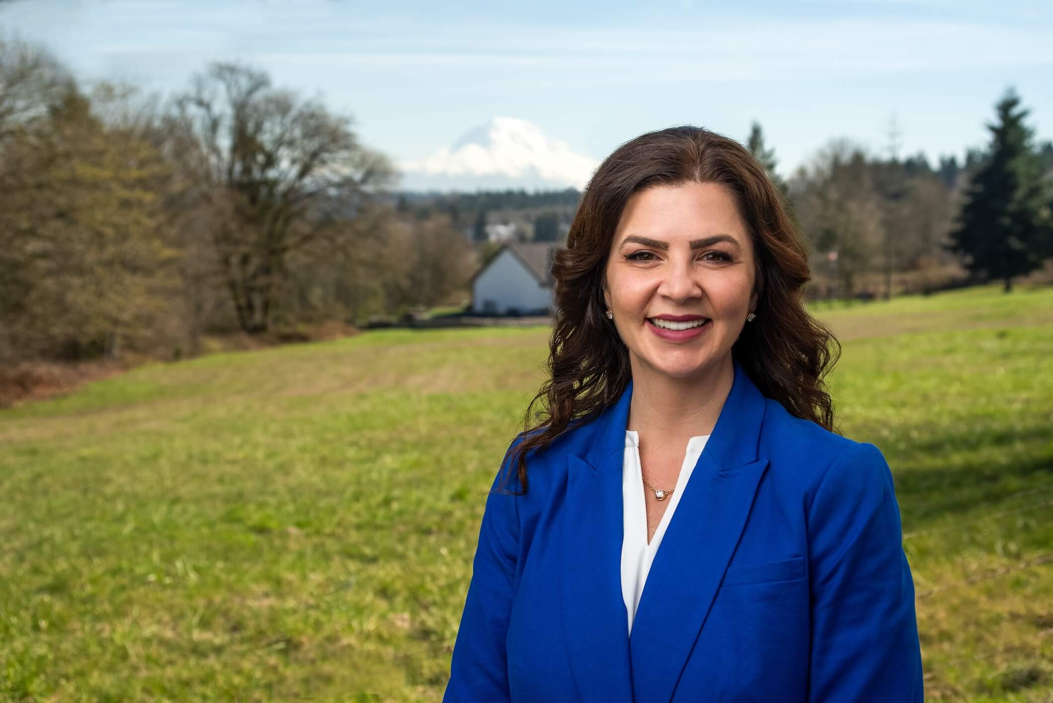 Headshot of Kelly Chambers standing outside in the grass on a farm